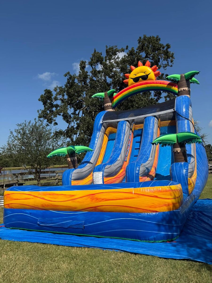 Tall blue and orange water slide with a rainbow arch, palm trees and a sun in sunglasses