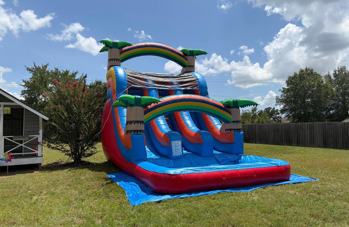 Red and blue tropical water slide with two rainbow arches and a long splash pool